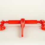 Heavy-duty ratchet load binder used for securing chains on trailer cargo, featuring a steel construction and ratcheting handle for tightening and safely tensioning loads during transport.