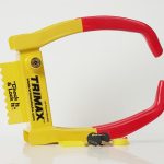 TRIMAX Wheel Chock Lock secured around a trailer wheel, designed to help prevent trailer movement and deter theft during storage or parking.