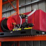 QR 150 fire suppression hydraulic skid system installed on a grain cart, featuring a compact tank and pump setup designed for rapid emergency fire response in agricultural field operations.