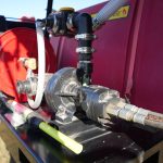 QR 150 fire suppression hydraulic skid system installed on a grain cart, featuring a compact tank and pump setup designed for rapid emergency fire response in agricultural field operations.