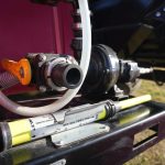 QR 150 fire suppression hydraulic skid system installed on a grain cart, featuring a compact tank and pump setup designed for rapid emergency fire response in agricultural field operations.