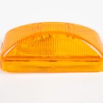 Amber plastic vehicle marker light cover stamped with "SAE PC" against a white background
