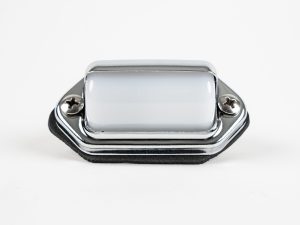Front-angled view of a surface-mount chrome-hooded license plate light featuring a high-polish finish, two Phillips mounting screws, black foam mounting gasket, and wiring leads against a white background.